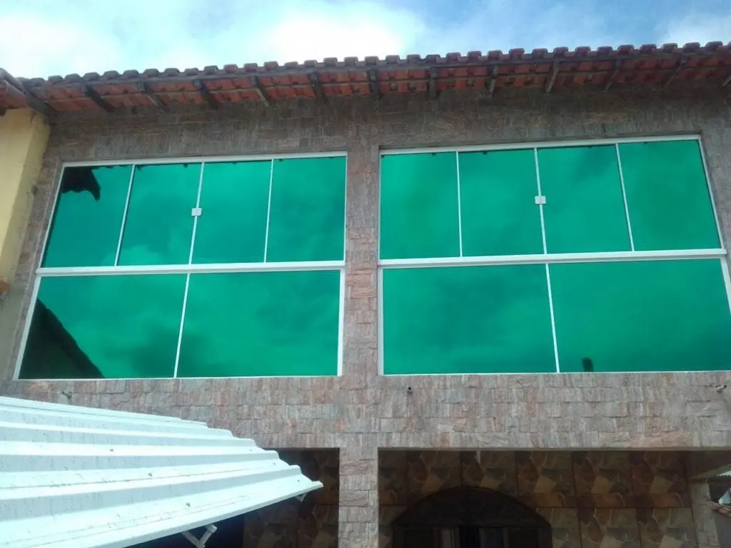 Insulfilm Barra da Tijuca: película espelhada verde aplicada em fachada residencial